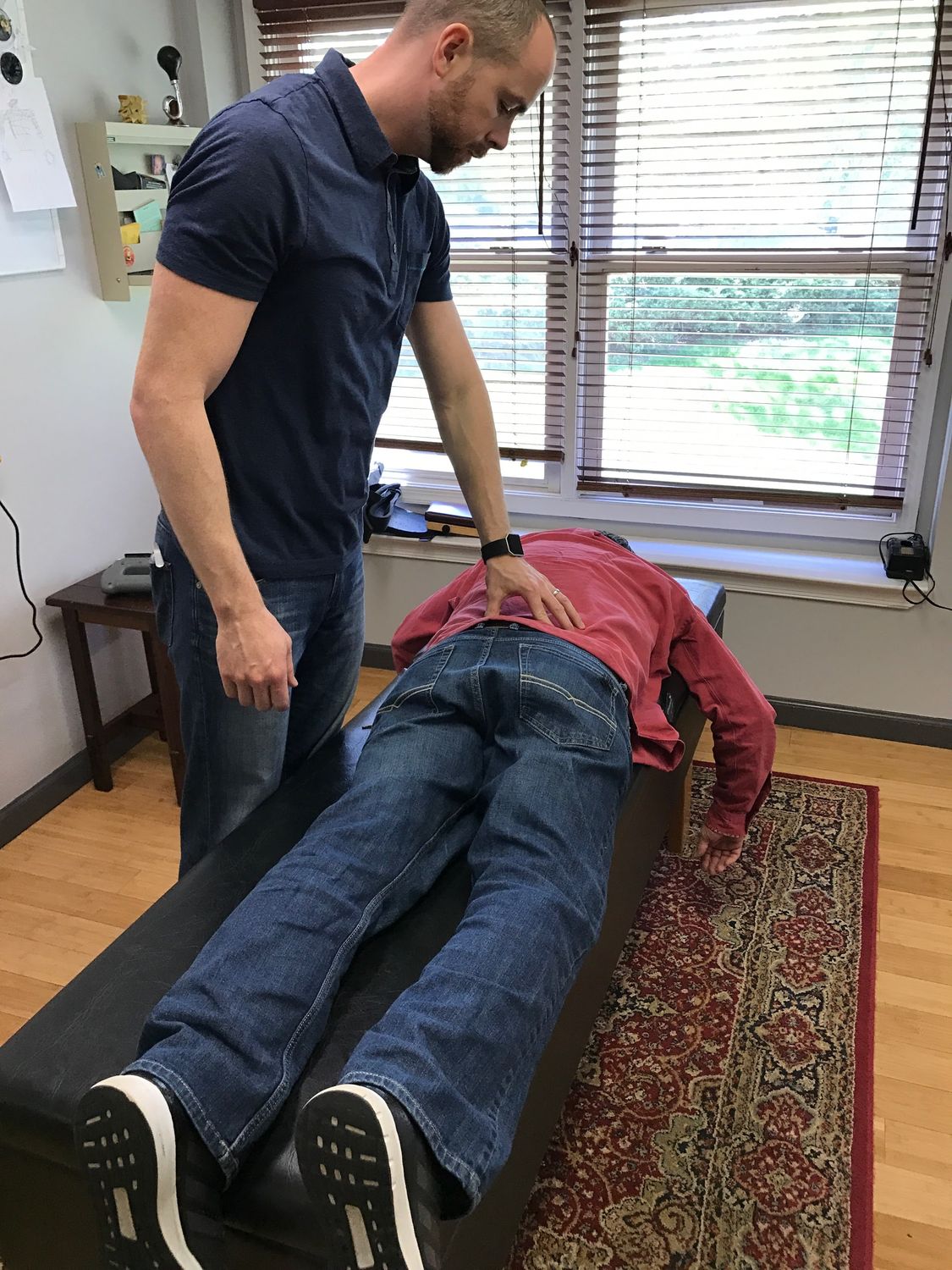 Dr. Tom McGuire adjusting a patient's lower back